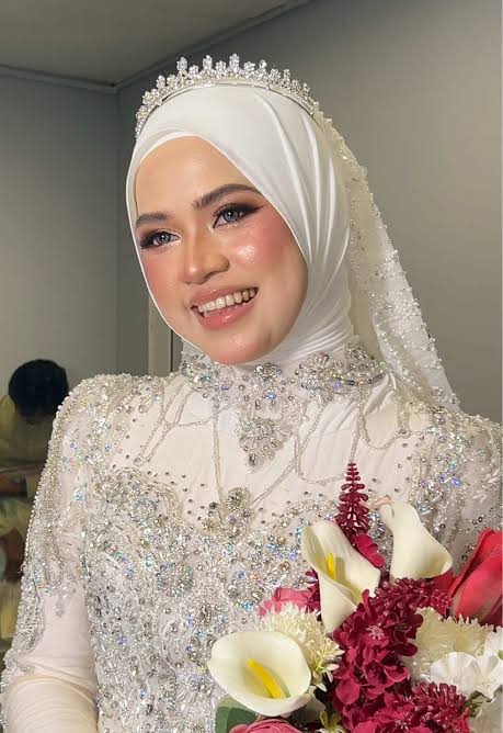 Bride wearing a white chiffon sheila wrapped with height at the crown and soft folds at the sides